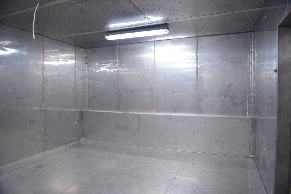 Inside the Haier environmental test chamber — white PIR finish, fire extinguishers at standby, sealed concrete floor