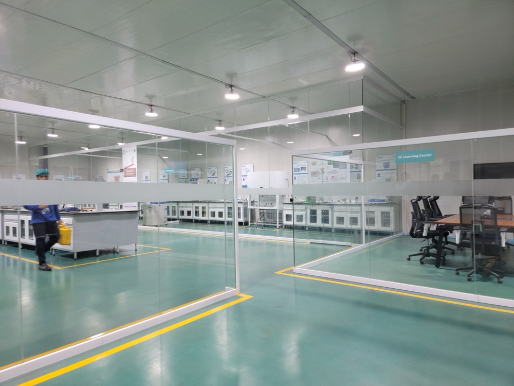 QC laboratory island bench detail at Naubahar Bottling Pepsi Gujranwala — sealed bay returns, brand-finished PIR walls